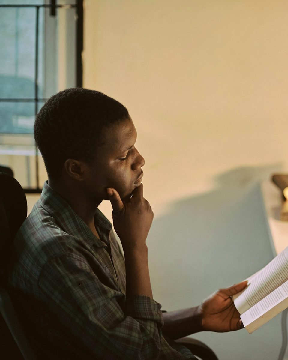 Person reading by lamplight next to an open laptop, representing the Awareness phase