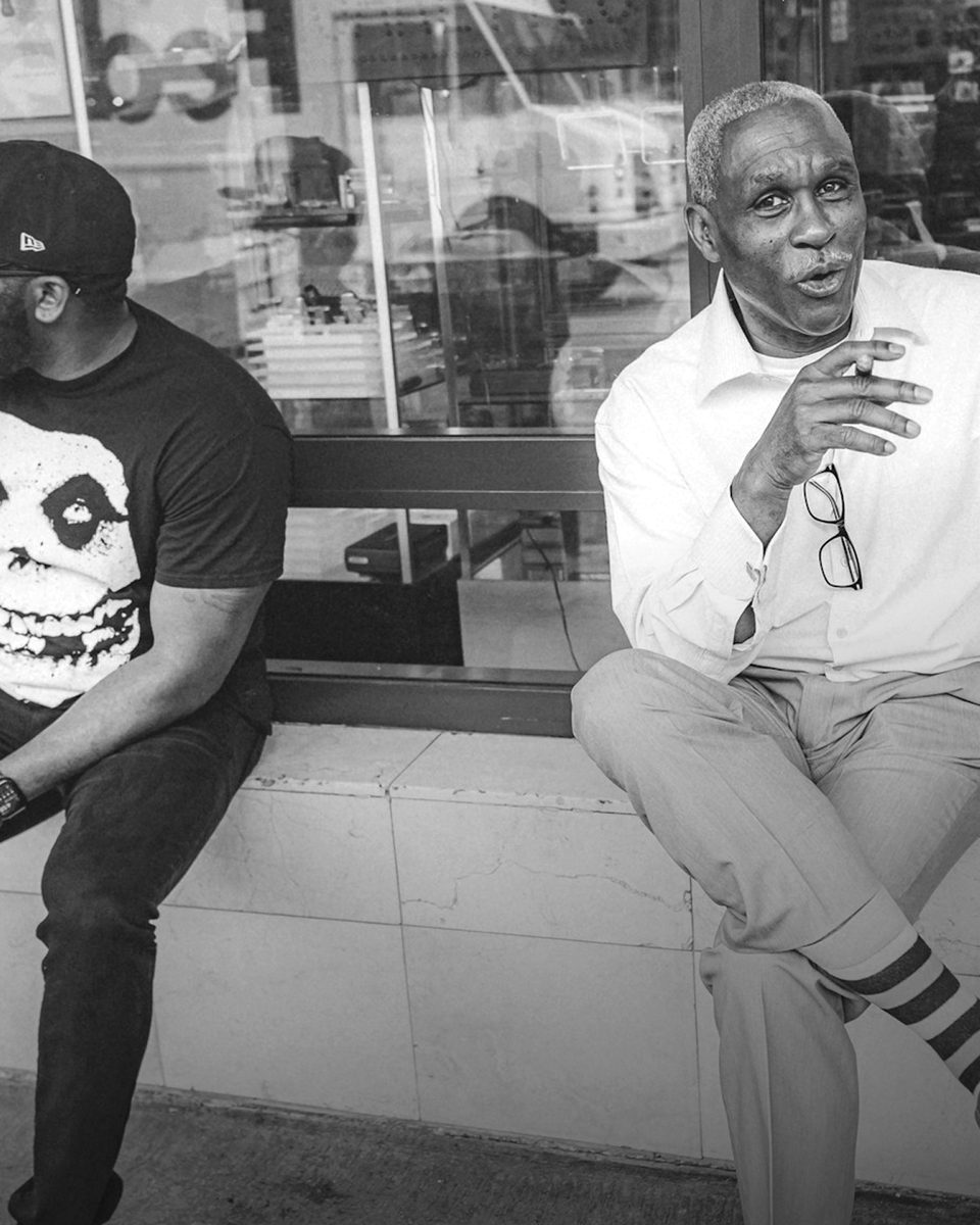 Two men in conversation on a city street, representing the Legacy phase